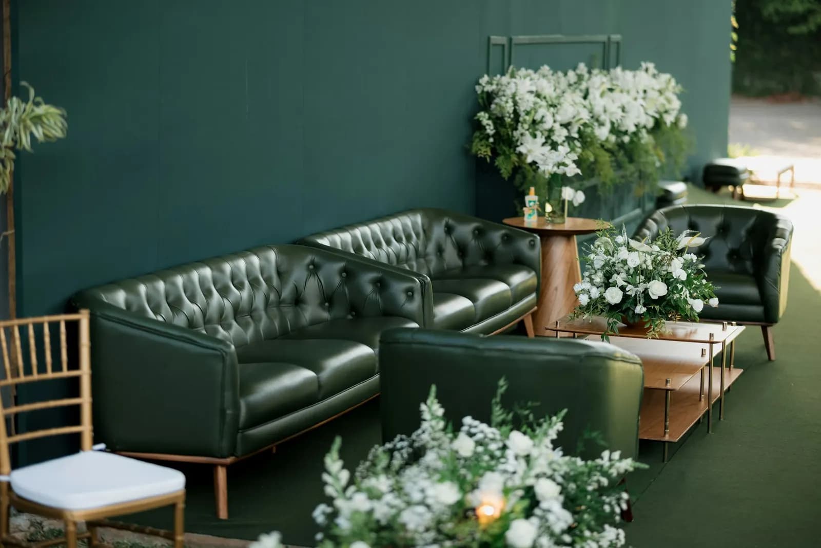 Green button-tufted chesterfield sofas