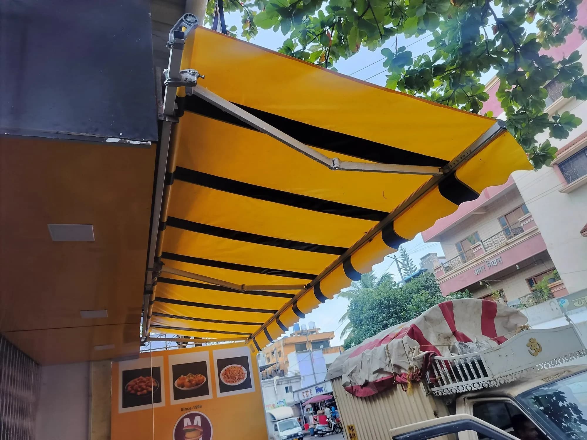 Folding-arm retractable awning extended over a shopfront
